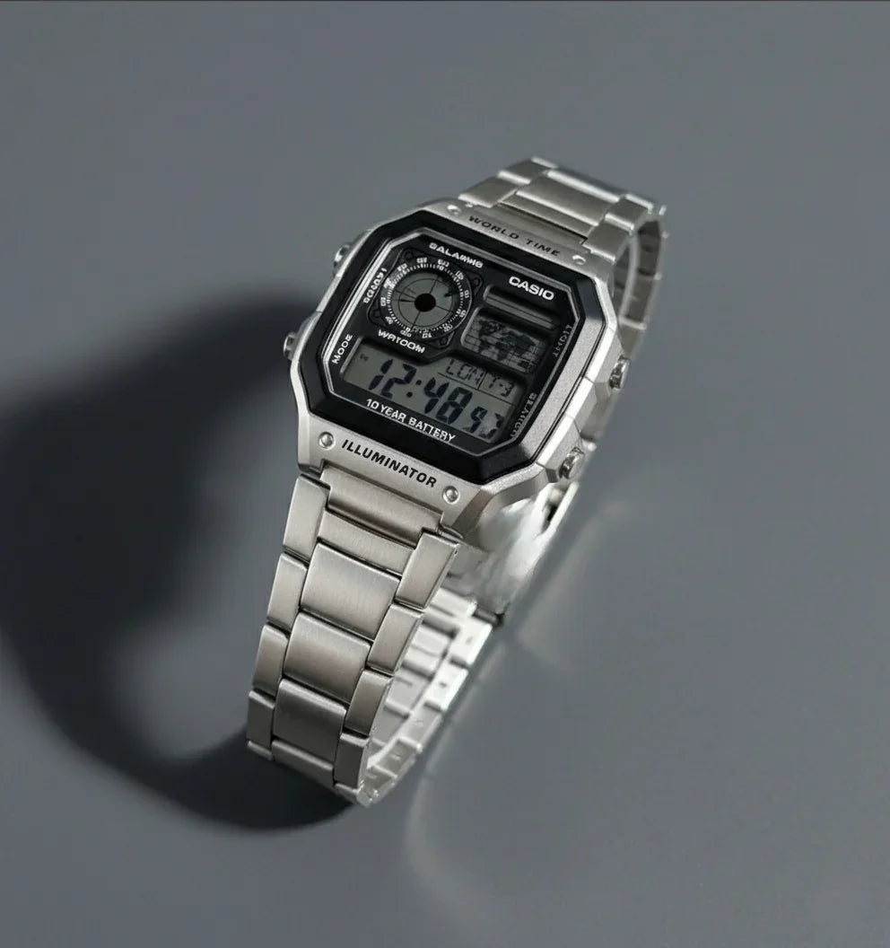 Silver digital stainless steel wristwatch with LED display and multiple dials on a gray background
